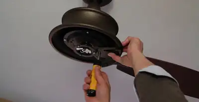 Electrician installing ceiling fan mounting bracket and fixture in Green Bay, WI