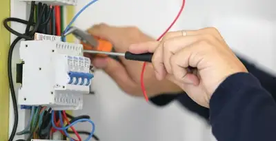 Electrician installing and adjusting circuit breakers in an electrical panel in Green Bay, WI
