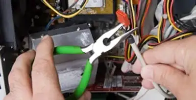 Licensed electrical contractor performing electrical repair with tools in De Pere, WI