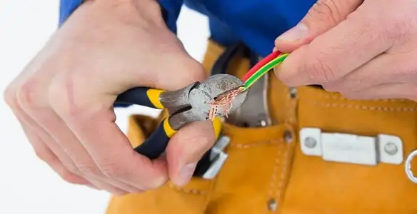 licensed electrician securing electrical wiring with professional tools during service work in Green Bay, WI