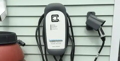 Outdoor electric vehicle charger installation on residential wall in Green Bay, WI