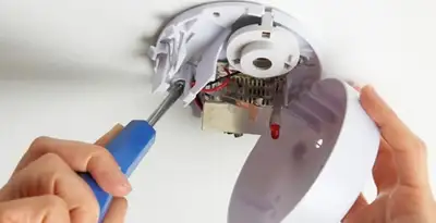 Certified technician wiring smoke detector during installation in Green Bay, WI